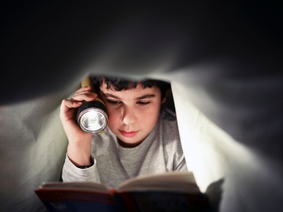 BLOG- kid reading under covers